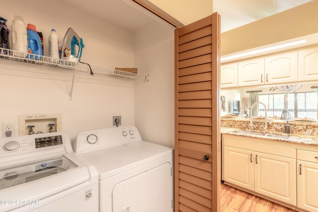 washroom featuring light hardwood / wood-style floors, sink, and washing machine and clothes dryer