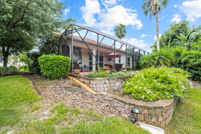 view of yard featuring glass enclosure and a patio area