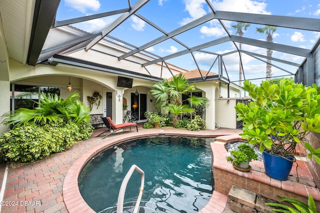 view of swimming pool with glass enclosure and a patio area