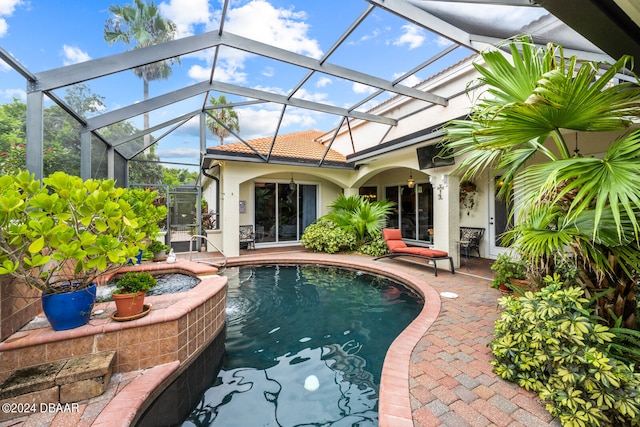 view of swimming pool featuring glass enclosure and a patio area