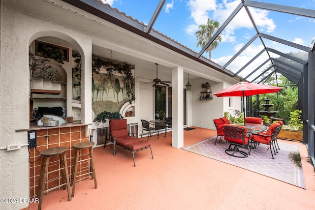 view of patio with a lanai, ceiling fan, and exterior bar