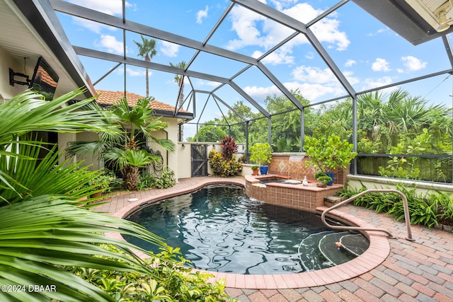 view of pool with a lanai, a hot tub, and a patio area