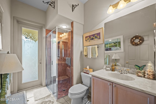 bathroom featuring toilet, vanity, tile patterned flooring, and a shower with door