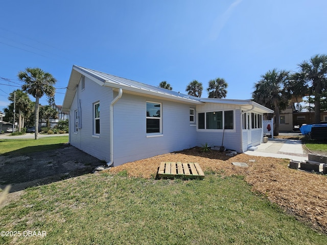 421 University Blvd, Daytona Beach, FL 32118 - back of house featuring a yard and metal roof