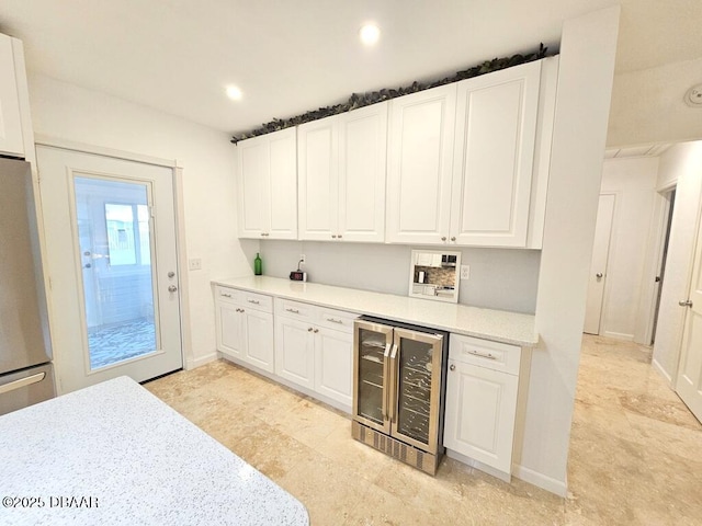 421 University Blvd, Daytona Beach, FL 32118 - kitchen with beverage cooler, freestanding refrigerator, white cabinets, and recessed lighting