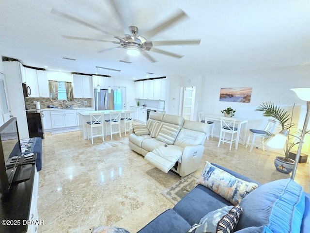 421 University Blvd, Daytona Beach, FL 32118 - living room featuring ceiling fan and light marble finish floors