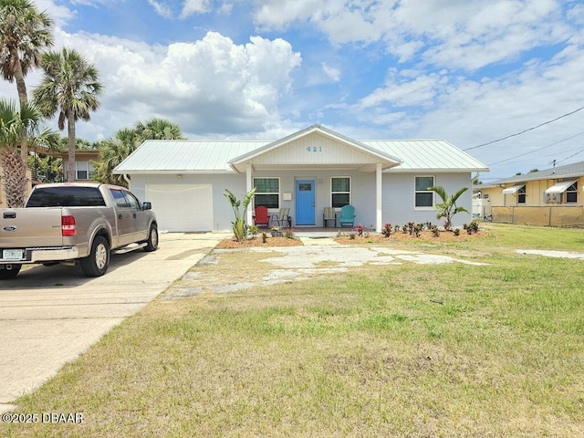 421 University Blvd, Daytona Beach, FL 32118 - ranch-style house with a garage, metal roof, concrete driveway, and covered porch