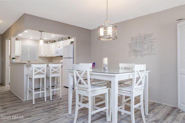 3606 S Peninsula Dr Unit 406, Port Orange, FL 32127 - dining space featuring light wood-type flooring, a chandelier, and recessed lighting