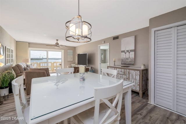 3606 S Peninsula Dr Unit 406, Port Orange, FL 32127 - dining area featuring a chandelier, wood finished floors, and a ceiling fan