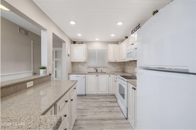 3606 S Peninsula Dr Unit 406, Port Orange, FL 32127 - kitchen featuring white appliances, light wood finished floors, white cabinets, light stone counters, and tasteful backsplash