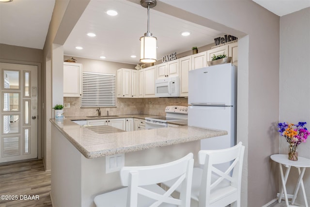 3606 S Peninsula Dr Unit 406, Port Orange, FL 32127 - kitchen with white appliances, light stone counters, backsplash, light wood-type flooring, and hanging light fixtures