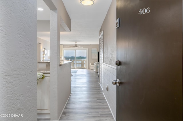 3606 S Peninsula Dr Unit 406, Port Orange, FL 32127 - corridor featuring a textured wall and wood finished floors