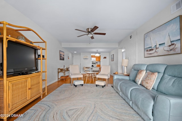 living room featuring hardwood / wood-style floors and ceiling fan