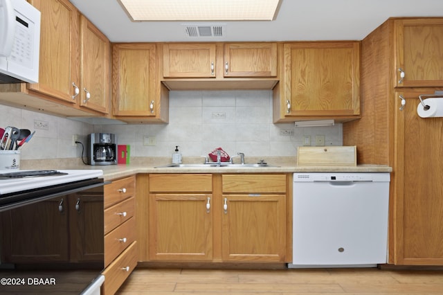 4175 S Atlantic Ave Unit 1130, New Smyrna Beach, FL 32169 - kitchen featuring white appliances, a sink, light countertops, decorative backsplash, and light wood finished floors