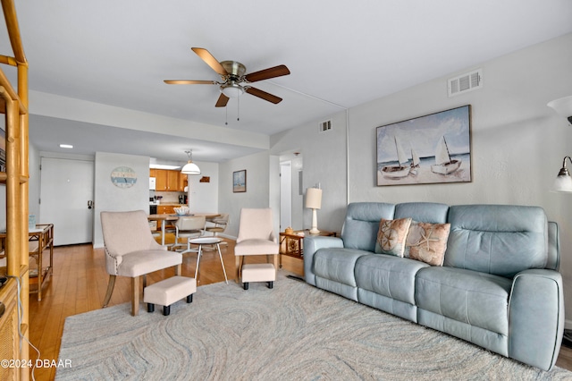 living room with ceiling fan and light hardwood / wood-style flooring