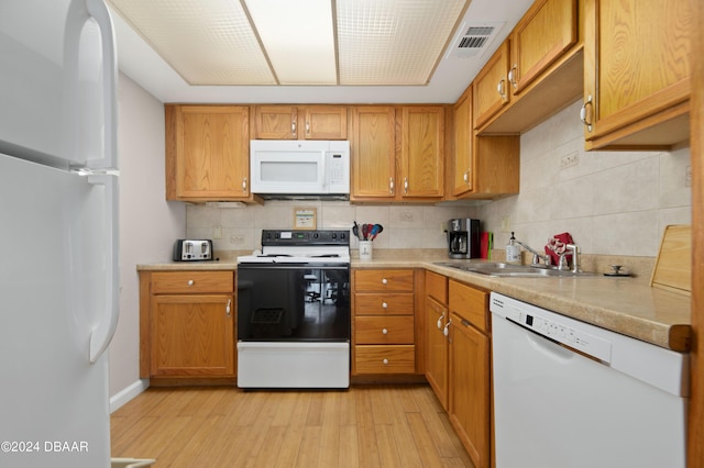 4175 S Atlantic Ave Unit 1130, New Smyrna Beach, FL 32169 - kitchen featuring white appliances, decorative backsplash, light wood finished floors, and light countertops