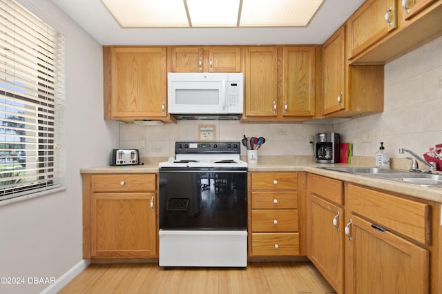 4175 S Atlantic Ave Unit 1130, New Smyrna Beach, FL 32169 - kitchen featuring electric stove, white microwave, a sink, and decorative backsplash