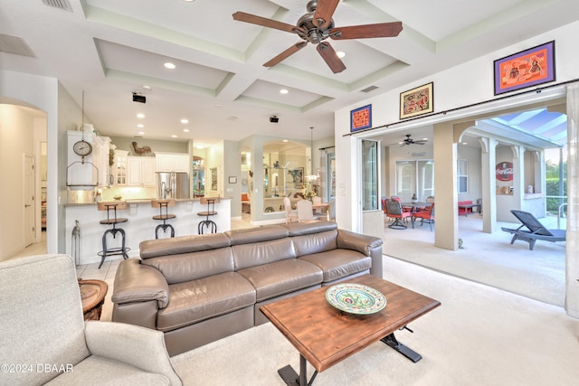 living room featuring light carpet, beam ceiling, ceiling fan, and coffered ceiling