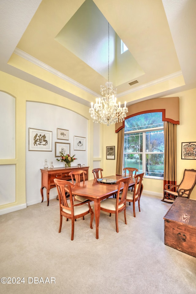 carpeted dining room with ornamental molding, a notable chandelier, and a tray ceiling