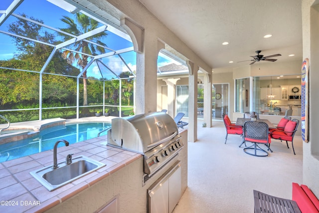 view of patio with sink, a pool with hot tub, ceiling fan, a grill, and glass enclosure