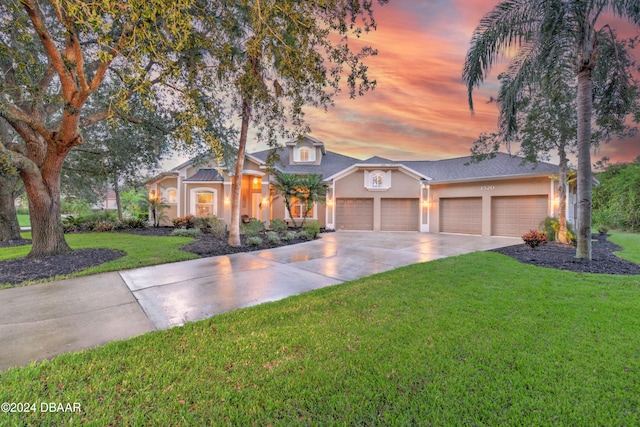 view of front of house with a garage and a yard