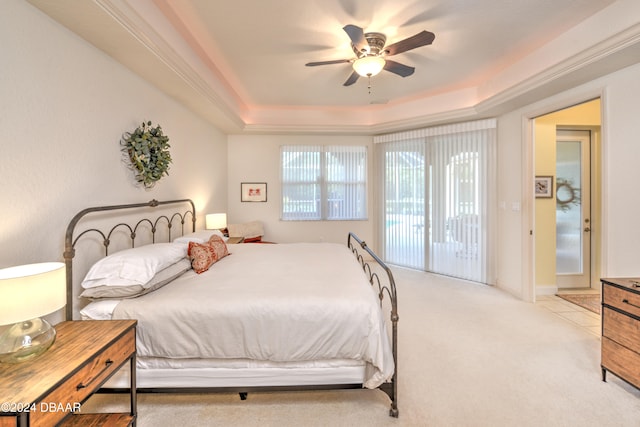 carpeted bedroom with a raised ceiling, ceiling fan, and access to exterior