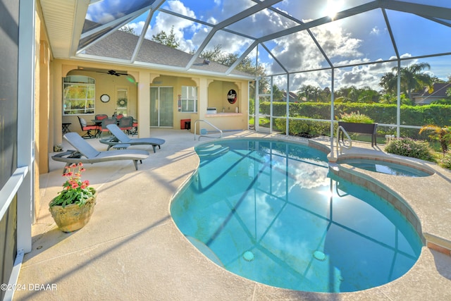 view of swimming pool with ceiling fan, a patio, a lanai, and an in ground hot tub