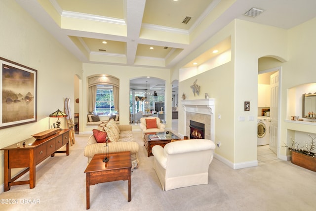 carpeted living room featuring coffered ceiling, crown molding, beam ceiling, a fireplace, and washer / clothes dryer