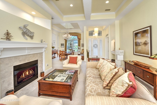 carpeted living room with beam ceiling, a notable chandelier, ornamental molding, and a fireplace