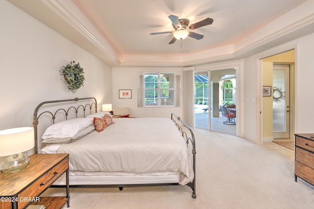 bedroom with light carpet, a raised ceiling, ceiling fan, and access to exterior