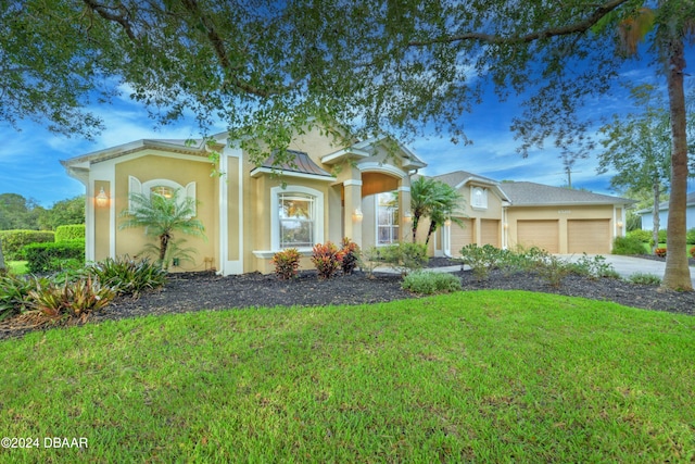 view of front of home featuring a garage and a front lawn