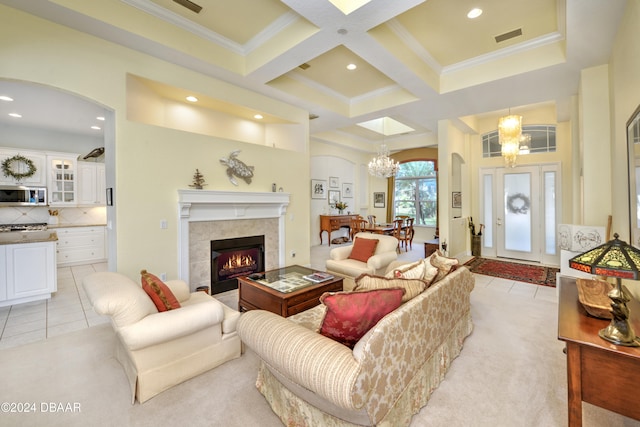 tiled living room featuring an inviting chandelier, coffered ceiling, beamed ceiling, crown molding, and a fireplace