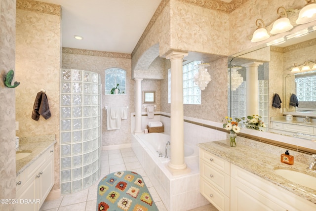 bathroom with vanity, decorative columns, a relaxing tiled tub, and tile patterned floors