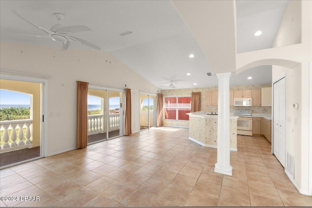 unfurnished living room with light tile patterned floors, ceiling fan, ornate columns, and high vaulted ceiling