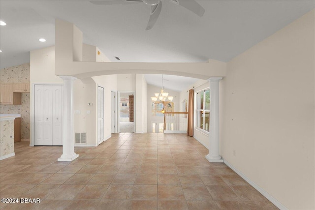 unfurnished living room with ceiling fan with notable chandelier, vaulted ceiling, and decorative columns