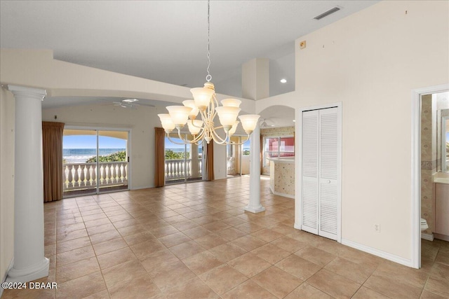 unfurnished dining area featuring light tile patterned floors, ornate columns, and ceiling fan with notable chandelier