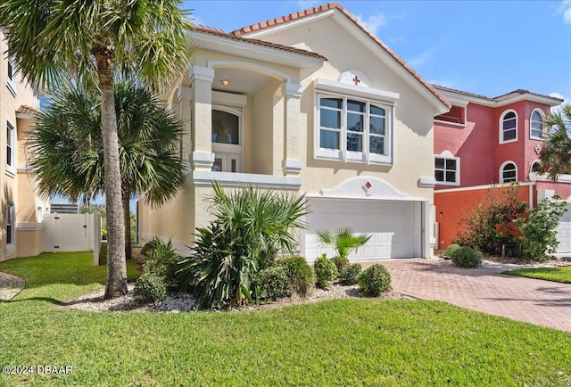 mediterranean / spanish house featuring a front lawn and a garage