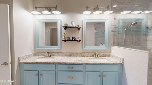 bathroom with a tile shower and vanity