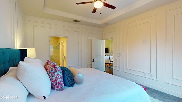 bedroom featuring a raised ceiling and ceiling fan