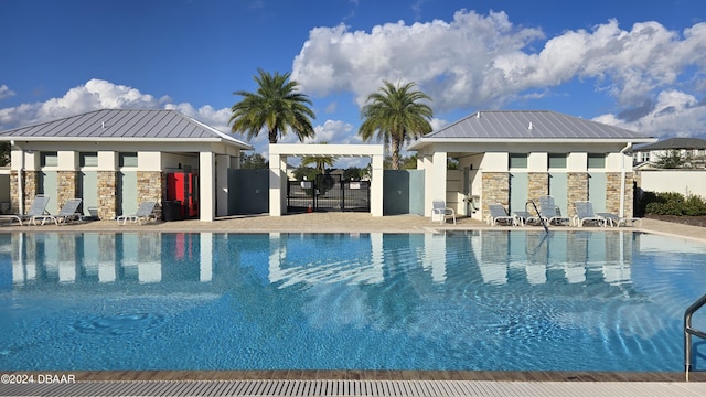 view of pool featuring an outbuilding and a patio