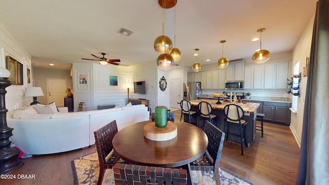 dining room with ceiling fan and wood-type flooring