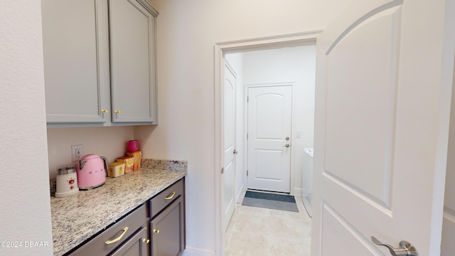 interior space featuring light stone countertops and gray cabinetry