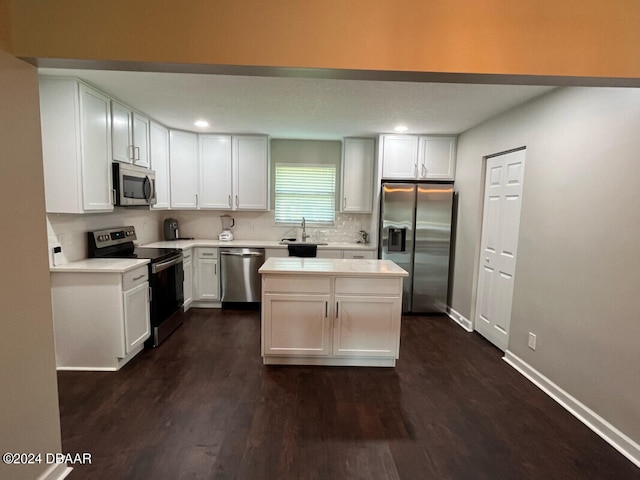 kitchen featuring dark hardwood / wood-style flooring, a center island, sink, white cabinetry, and appliances with stainless steel finishes