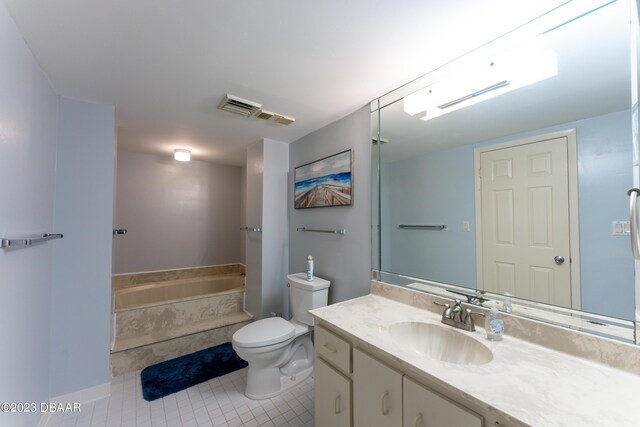 bathroom with tile patterned floors, toilet, vanity, and tiled tub