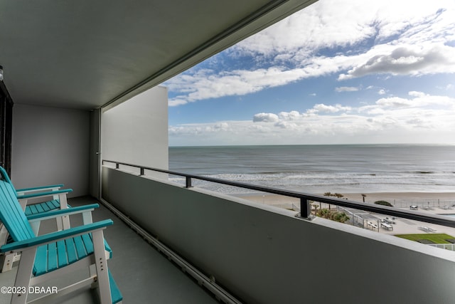 balcony featuring a water view and a view of the beach