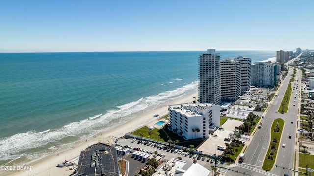 drone / aerial view featuring a water view and a view of the beach