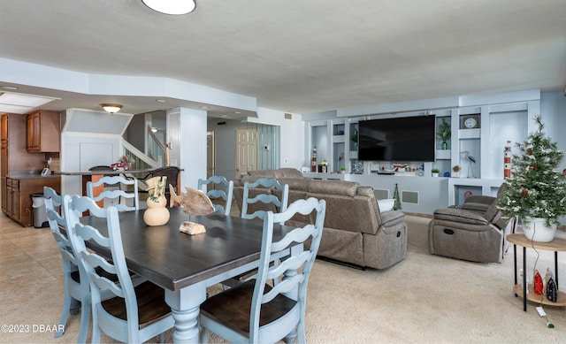 dining space featuring light colored carpet and built in shelves