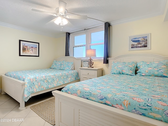 tiled bedroom featuring ceiling fan, ornamental molding, and a textured ceiling