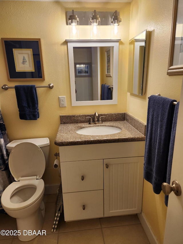 bathroom featuring vanity, tile patterned flooring, and toilet