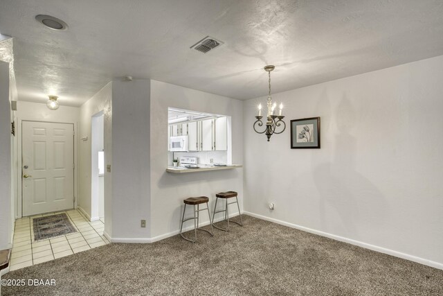 carpeted foyer entrance with baseboards and a chandelier